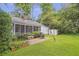 View of a well-maintained backyard with a screened porch and brick patio perfect for entertaining at 1908 E Roxboro Ne Rd, Atlanta, GA 30324