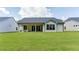 Back of home featuring sliding doors to patio and large green yard at 313 Sobeck Way, Canton, GA 30115