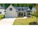 Charming white brick home with black trim, a well-manicured lawn and a welcoming front porch at 313 Sobeck Way, Canton, GA 30115