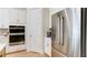 Stainless steel refrigerator and built-in ovens complement the white cabinetry in the kitchen at 313 Sobeck Way, Canton, GA 30115