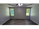 Primary bedroom with tray ceilings, two windows, ceiling fan, and wood-look flooring at 1513 Foxhall Se Ln, Atlanta, GA 30316