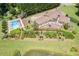 Drone view showing a home with pool, patio, garden, and a serene pond, surrounded by lush greenery at 317 Red Gate Overlook, Canton, GA 30115