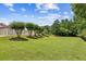 Expansive backyard featuring a well-manicured lawn, mature trees, and a partial view of a serene lake at 317 Red Gate Overlook, Canton, GA 30115