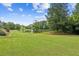 Expansive lawn leads to a tranquil pond, creating a serene and picturesque backyard oasis at 317 Red Gate Overlook, Canton, GA 30115