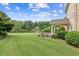 Lush backyard with manicured lawn, stone bench seating, and serene pond views for relaxing outdoors at 317 Red Gate Overlook, Canton, GA 30115