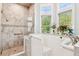 Elegant bathroom with a walk-in tub, marble shower, and large window views at 317 Red Gate Overlook, Canton, GA 30115