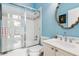 Bathroom featuring a tiled shower, white vanity, and decorative mirror at 317 Red Gate Overlook, Canton, GA 30115