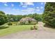 Beautiful home with a well-maintained lawn, mature trees, pond, and long driveway leading to the residence at 317 Red Gate Overlook, Canton, GA 30115