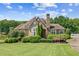 Stunning single-story home boasting stone accents, manicured landscaping, and a sprawling front yard with a tranquil pond at 317 Red Gate Overlook, Canton, GA 30115