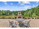 Brick patio features an outdoor fireplace and comfortable seating overlooking a lake at 317 Red Gate Overlook, Canton, GA 30115