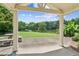 Covered patio with stone table seating overlooking a lush lawn and a peaceful lake at 317 Red Gate Overlook, Canton, GA 30115