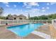 Inviting in-ground pool surrounded by white fencing and lush greenery creates a tranquil backyard oasis at 317 Red Gate Overlook, Canton, GA 30115