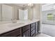 Bright bathroom featuring double sinks, white countertops and wood cabinets at 3705 Williams Point Dr, Cumming, GA 30028