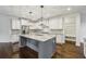 Bright kitchen featuring a large island with pendant lighting, white cabinets, and stainless steel appliances at 3705 Williams Point Dr, Cumming, GA 30028