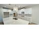 A bright kitchen features white cabinets, a large center island, modern appliances, and stylish pendant lighting at 4850 Cool Springs Rd, Winston, GA 30187