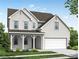 Charming two-story home with white brick, a covered porch, manicured lawn, and an attached two-car garage at 6934 Melody Ridge Rd, Buford, GA 30518