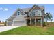 Attractive two-story home featuring a three-car garage and inviting front porch at 6934 Melody Ridge Rd, Buford, GA 30518