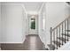 Bright hallway with hardwood floors, view of stairway, and white trim at 6934 Melody Ridge Rd, Buford, GA 30518