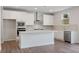 Well-lit kitchen with white cabinets, stainless steel appliances, and center island with white countertop at 6934 Melody Ridge Rd, Buford, GA 30518