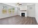 Bright living room featuring wood-look flooring, a ceiling fan, and a fireplace with a decorative mantel at 6934 Melody Ridge Rd, Buford, GA 30518