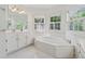 Bright bathroom features a soaking tub beneath large windows, providing natural light at 240 Old Plantation Way, Fayetteville, GA 30214
