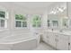 An all-white bathroom featuring a large soaking tub, vanity, and windows that offer outside views at 240 Old Plantation Way, Fayetteville, GA 30214