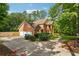 Side angle of a two-story brick home with lush landscaping, attached garage, and paved driveway at 240 Old Plantation Way, Fayetteville, GA 30214