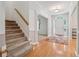 Bright foyer with hardwood floors, staircase, white trim, and view into the living spaces at 240 Old Plantation Way, Fayetteville, GA 30214
