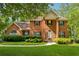 Charming two-story red brick home with a well-manicured lawn and lush green landscaping at 240 Old Plantation Way, Fayetteville, GA 30214