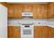 Kitchen showcasing oak cabinets, a white microwave, and a range at 240 Old Plantation Way, Fayetteville, GA 30214