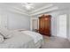Main bedroom boasting tray ceilings, an accent armoire, and neutral decor at 240 Old Plantation Way, Fayetteville, GA 30214