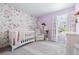 Charming Bedroom with floral wallpaper, crib, and soft, pastel accents at 3554 Bluebird Ct, Atlanta, GA 30331