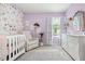 Charming Bedroom with floral wallpaper, crib, and soft, pastel accents at 3554 Bluebird Ct, Atlanta, GA 30331