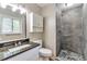 Modern bathroom with tiled shower, granite countertop and dark, marbled vanity at 5215 Mainstreet Park Dr, Stone Mountain, GA 30088