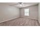 Bright bedroom featuring plush carpeting, ceiling fan, and a window allowing natural light at 5215 Mainstreet Park Dr, Stone Mountain, GA 30088