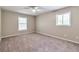 Bedroom with 2 windows, plush carpet, and a ceiling fan providing comfort and style at 5215 Mainstreet Park Dr, Stone Mountain, GA 30088
