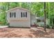 Charming two-story home with light siding, black shutters, and surrounded by lush greenery at 5215 Mainstreet Park Dr, Stone Mountain, GA 30088