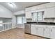 Open-concept kitchen shows stainless dishwasher, white cabinets, and granite countertops at 5215 Mainstreet Park Dr, Stone Mountain, GA 30088