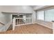 Open living space with wood-look flooring showing staircase and stone fireplace at 5215 Mainstreet Park Dr, Stone Mountain, GA 30088