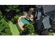 Aerial view of the property with pool, putting green, patio, and mature trees at 217 Fernwood Pl, Woodstock, GA 30188