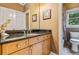 Bathroom with granite counters, wood cabinets, tiled floors, and natural light at 217 Fernwood Pl, Woodstock, GA 30188