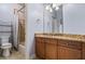 Well-lit bathroom with warm granite counters, wood cabinets, shower and tiled floors at 217 Fernwood Pl, Woodstock, GA 30188