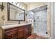 Elegant bathroom with a glass-enclosed shower, stone accents, and a dark wood vanity at 217 Fernwood Pl, Woodstock, GA 30188