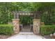 Stone archway entrance to a wooden bridge walkway at 217 Fernwood Pl, Woodstock, GA 30188