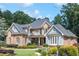 Attractive brick and blue paneled two-story home with manicured lawn, garden beds, and mature shade trees at 217 Fernwood Pl, Woodstock, GA 30188