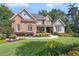 Charming brick home features manicured lawn, lush garden beds, and beautiful shrubs at 217 Fernwood Pl, Woodstock, GA 30188