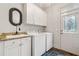 Laundry room with washer, dryer, utility sink, and storage cabinets, offering functionality and convenience at 217 Fernwood Pl, Woodstock, GA 30188