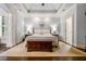 A luxurious primary bedroom with a tray ceiling and hardwood flooring is the perfect retreat at 217 Fernwood Pl, Woodstock, GA 30188