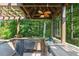 Covered outdoor kitchen features brick flooring, bar seating, stainless appliances and Green Egg grill at 217 Fernwood Pl, Woodstock, GA 30188