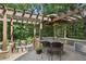 Covered outdoor kitchen featuring granite counters, bar seating and natural light at 217 Fernwood Pl, Woodstock, GA 30188